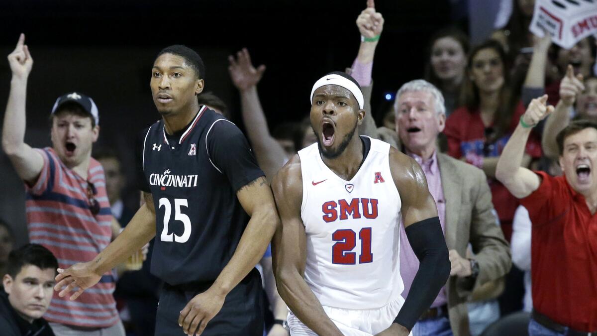 SMU guard Ben Emelogu II (21) reacts to a call next to Cincinnati guard Kevin Johnson (25) during the second half Sunday.