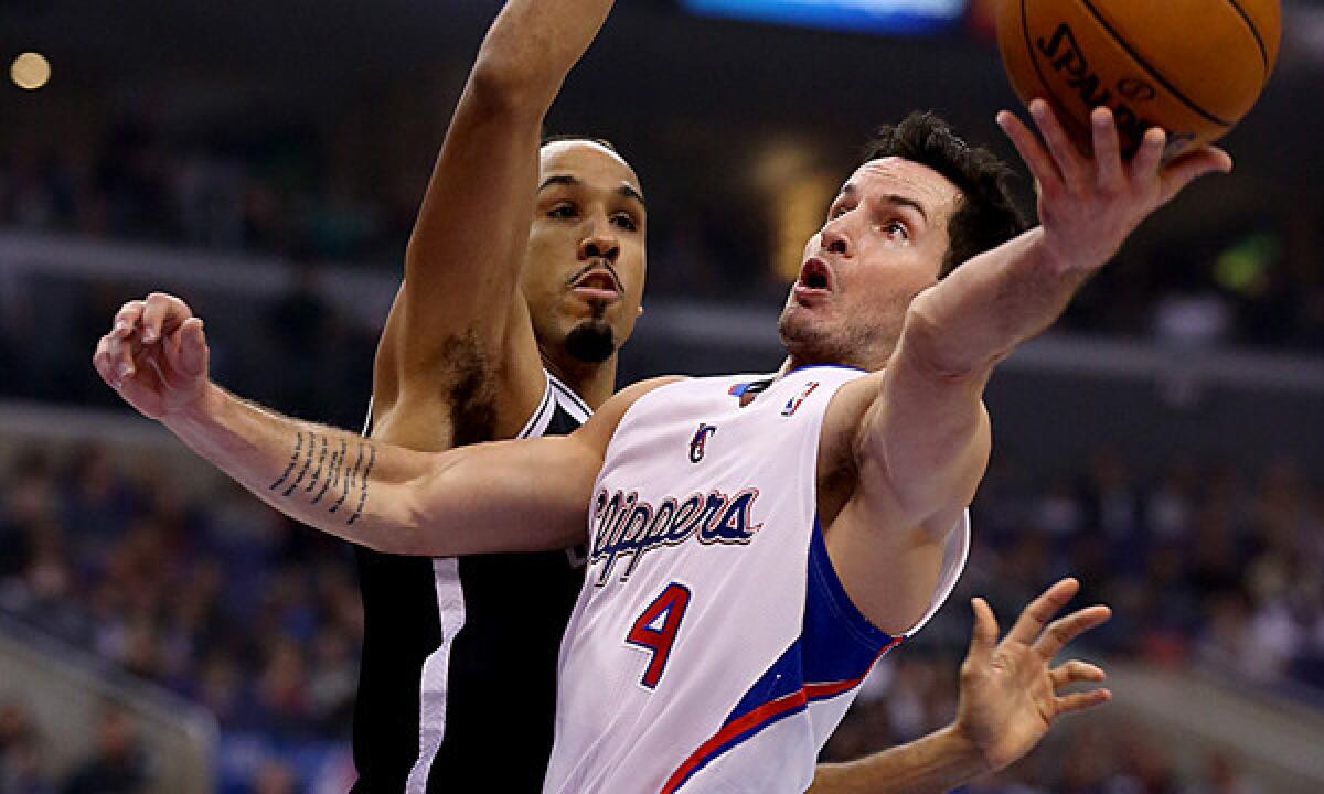 Clippers guard J.J. Redick, right, puts up a shot in front of Brooklyn Nets guard Shaun Livingston during a game on Nov. 16. Clippers Coach Doc Rivers isn't sure when Redick will make his return from a back injury that has sidelined him for two months.