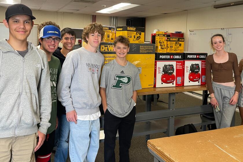 Poway High construction students display donated tools that helped them return to their woodworking projects.