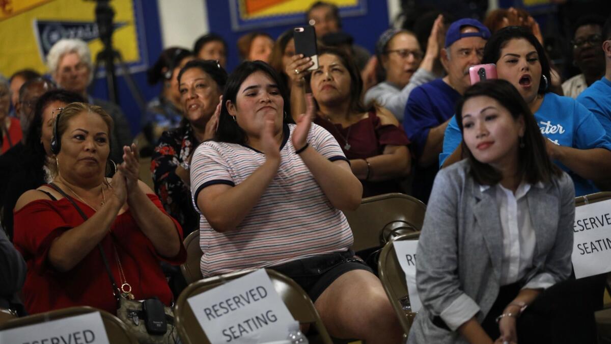 Residents express disapproval of Sativa Los Angeles County Water District at a June meeting as Sativa's general manager, Maria Garza, right, leans away from the crowd.