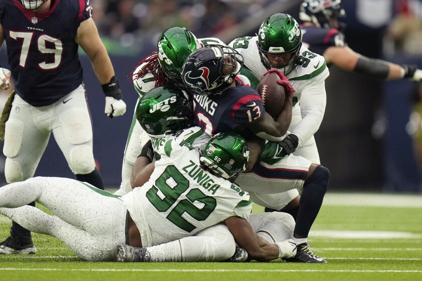 Houston Texans wide receiver Brandin Cooks (13) is stopped by New York Jets defensive end Jabari Zuniga (92), defensive end Kyle Phillips (93) and middle linebacker C.J. Mosley (57) in the first half of an NFL football game in Houston, Sunday, Nov. 28, 2021. (AP Photo/Eric Smith)