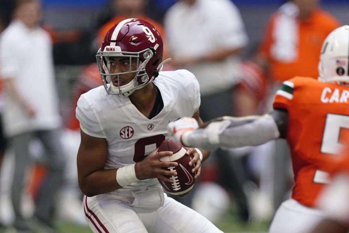 Alabama quarterback Bryce Young (9) looks for an open receiver under pressure from the Miami defense during the second half of an NCAA college football game Saturday, Sept. 4, 2021, in Atlanta. (AP Photo/John Bazemore)