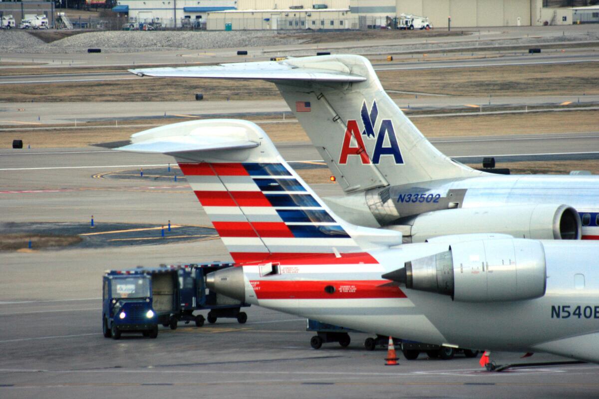 In this Dec. 2013 file photo crews work around two American Airlines jets in St. Louis. A computer problem has grounded flights heading Thursday morning into Dallas, Chicago and Miami.