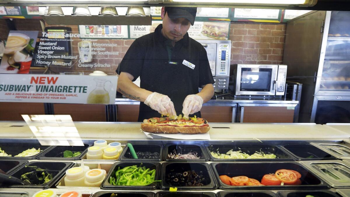 A worker makes a sandwich at a Subway sandwich franchise in Seattle on March 3, 2015.