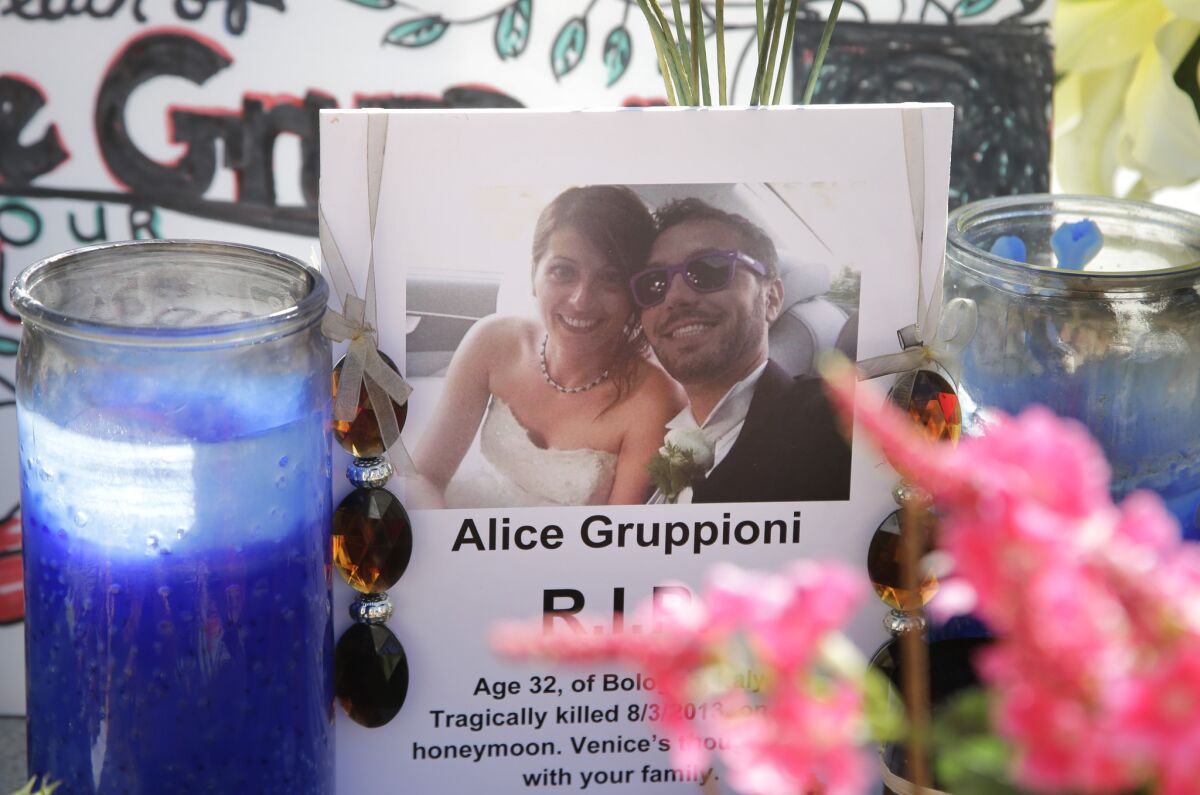 In this Aug. 5, 2013, file photo, a card showing a photo of Italian newlyweds Alice Gruppioni and her husband, Christian Casadei, is part of a makeshift memorial for Gruppioni along Ocean Front Walk at Venice Beach.