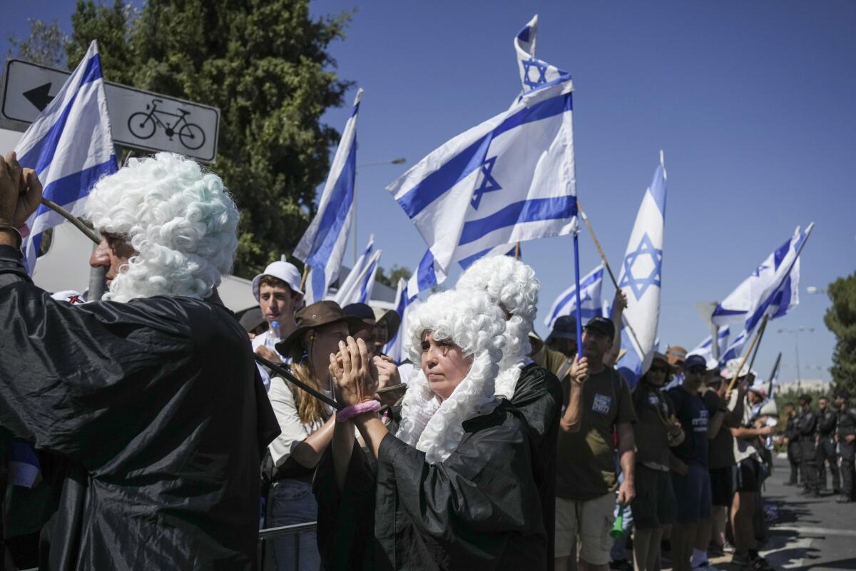 Protesters dressed as judges and waving Israeli flags