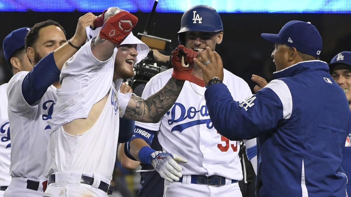 Alex Verdugo celebrates with Dodgers teammates who tore off his jersey after his game-winning home run.