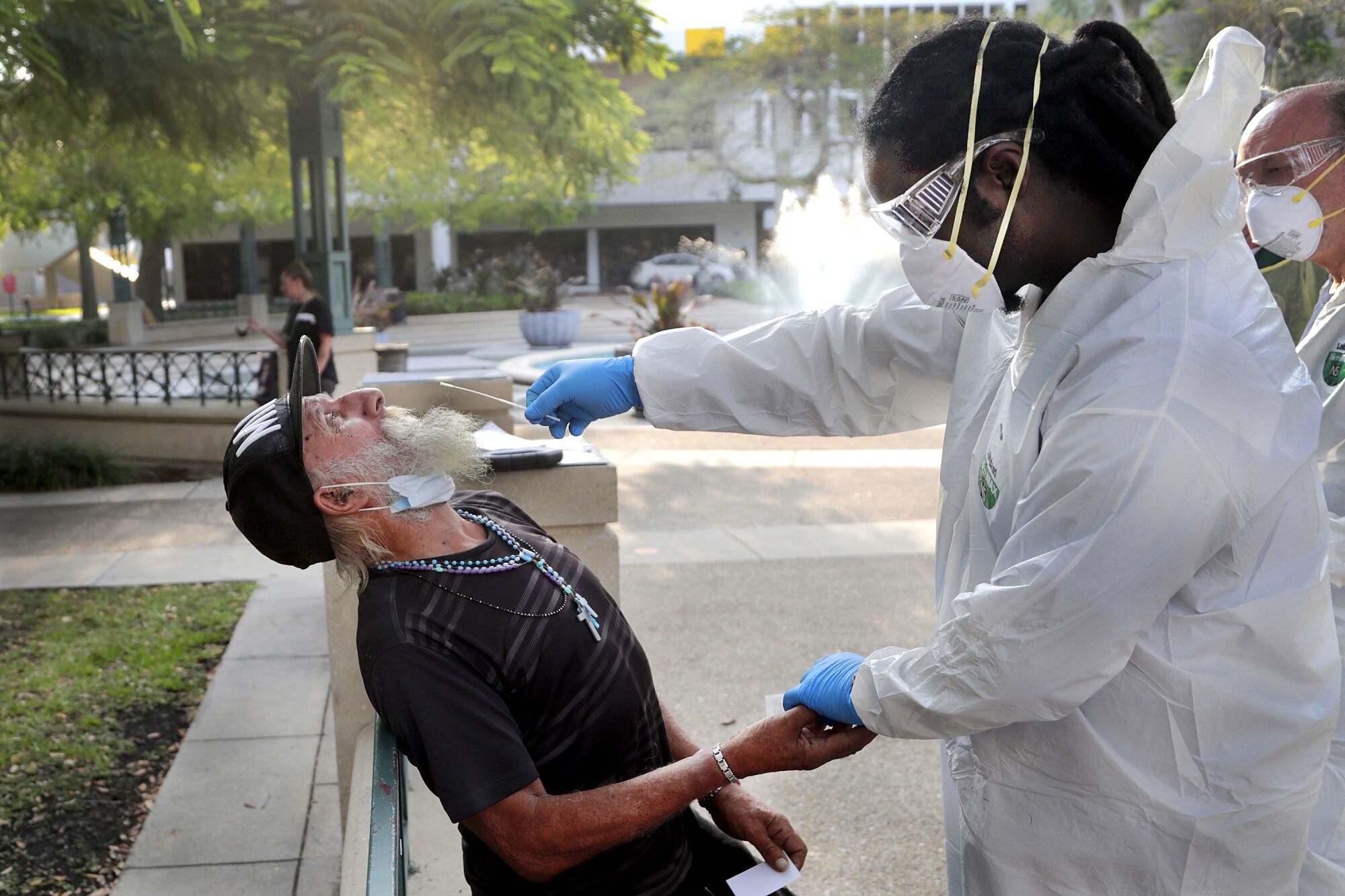 FLORIDA: Nurse practitioner Gregory Pierre holds the hand of Leonardo Toledo Martinez, who is homeless, as he is tested for COVID-19 in Miami on April 16.