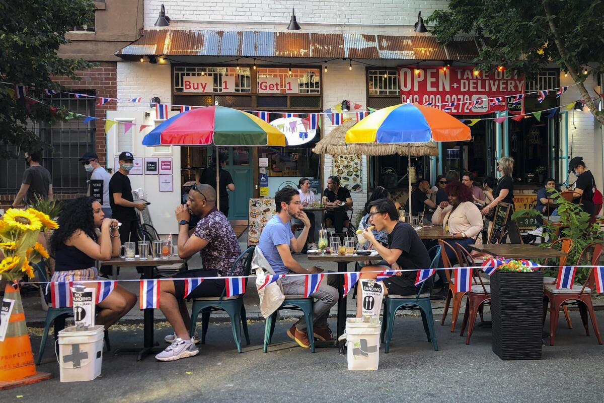 Comensales almuerzan en la acera en Nueva York, 26 de junio de 2020.