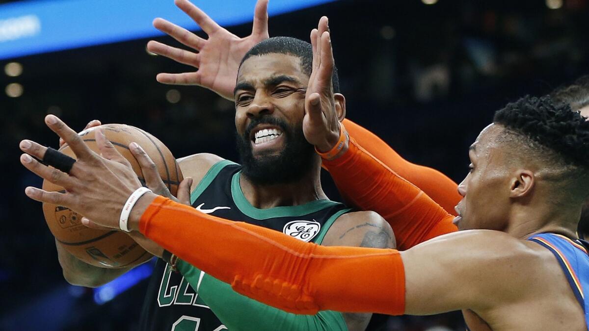 Celtics guard Kyrie Irving tries to power his way past Thunder guard Russell Westbrook during the first half Sunday.
