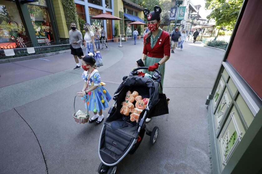 ANAHEIM, CA - NOVEMBER 19: April Levar and daughter Ruth walk along Downtown Disney District for some shopping. Disney California Adventure opened on Thursday, Nov. 19, 2020 in Anaheim, CA without rides but with plenty of dining and shopping opportunities. (Myung J. Chun / Los Angeles Times)