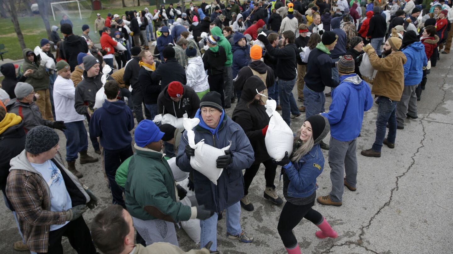 Volunteers form a human chain as they help load sandbags Tuesday in St. Louis.