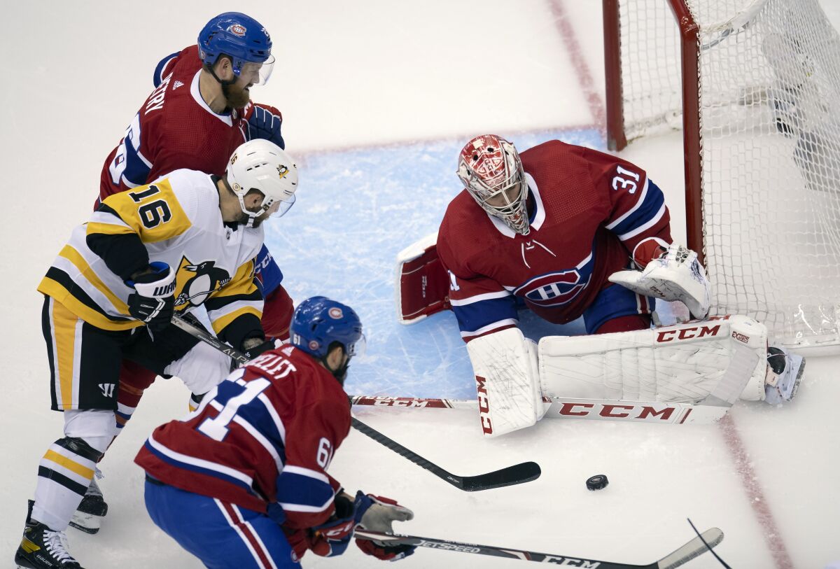 Montreal Canadiens goaltender Carey Price (31) makes a save on Pittsburgh Penguins left wing Jason Zucker (16) as Canadiens defensemen Jeff Petry (26) and Xavier Ouellet (61) help out during the first period of an NHL hockey playoff game Friday, Aug. 7, 2020, in Toronto. (Frank Gunn/The Canadian Press via AP)