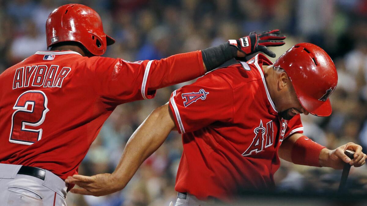 Angels teammates Erick Aybar, left, and Albert Pujols celebrate after scoring runs in the fifth inning of the team's 8-3 win over the Boston Red Sox on Wednesday.