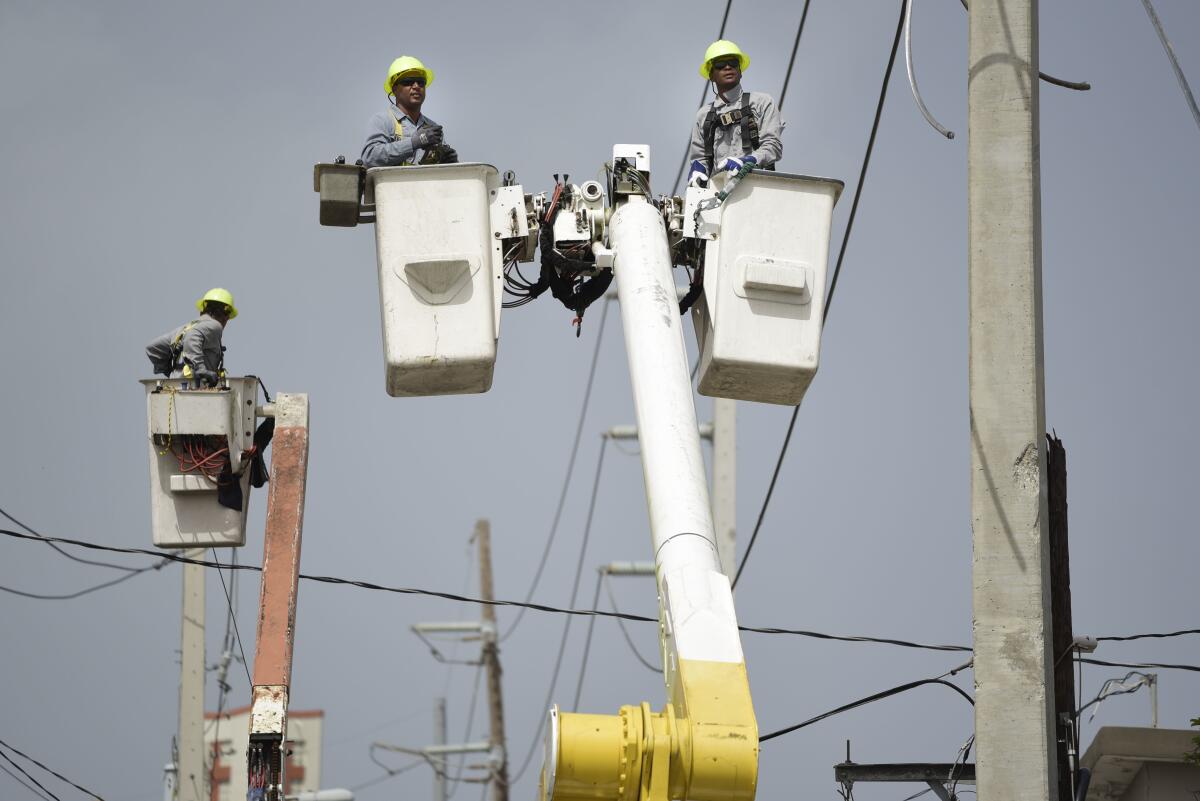 Workers with Puerto Rico's Electric Power Authority repair distribution lines