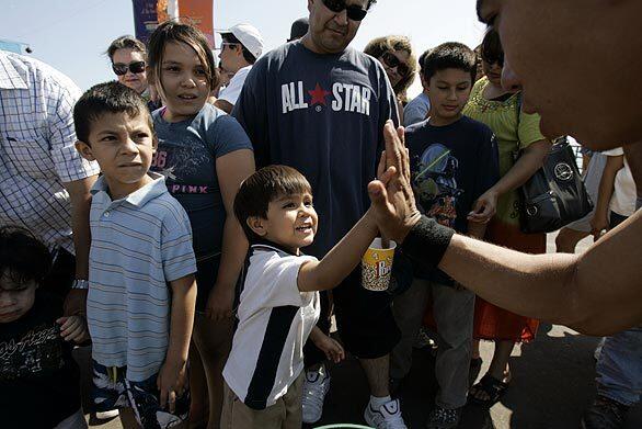 Albert Hinogosa, 5, meets Manny Guerrero, a member of the Mala Vida street dance group, on the Santa Monica Pier.