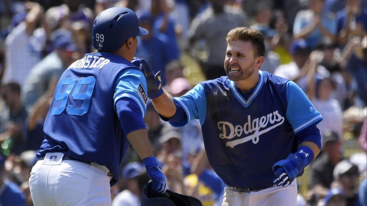 The Dodgers' Hyun-Jin Ryu, left, and Brian Dozier celebrate after they scored on a double by Justin Turner during the fifth inning against the San Diego Padres on Sunday.