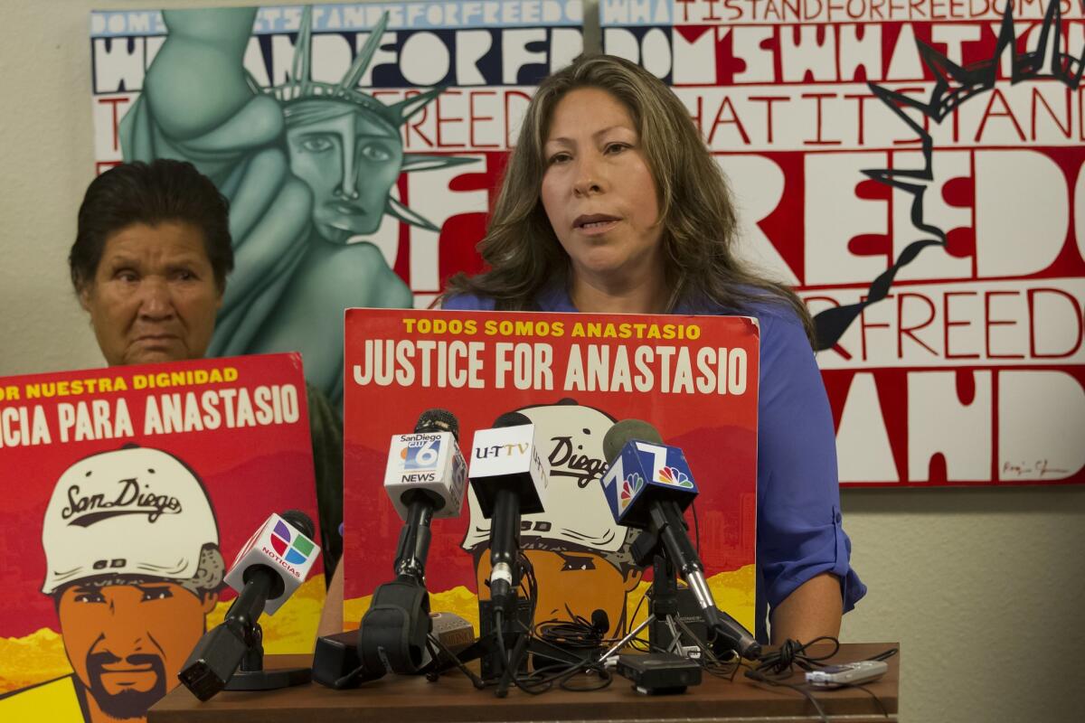 The mother and widow of Anastasio Hernandez Rojas stand together with signs calling for justice.