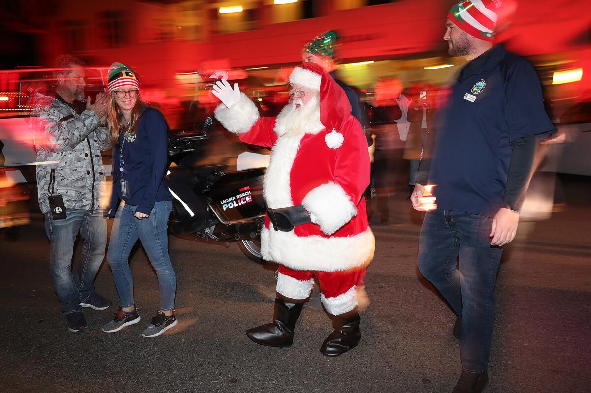 Santa arrives on Ocean Avenue to light the Pepper Tree during Hospitality Night in downtown Laguna Beach on Friday.