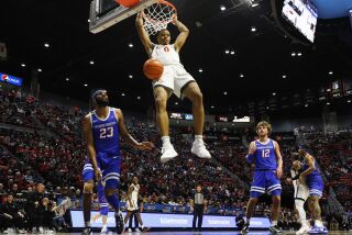 San Diego CA - February 3: San Diego State's Keshad Johnson dunks on an alley-oop in front of Boise State's Naje Smith on Friday, February 3, 2023. (K.C. Alfred / The San Diego Union-Tribune)