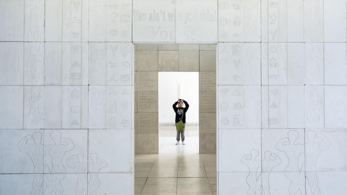 A visitor walks through Lauren Halsey's monument prototype at the Hammer Museum's "Made in L.A" biennial.