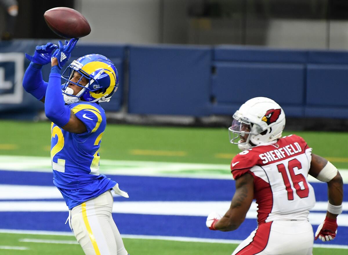 The Rams' Troy Hill intercepts a pass in front of the Cardinals' Trent Sherfield and turns the catch into a pick-six.