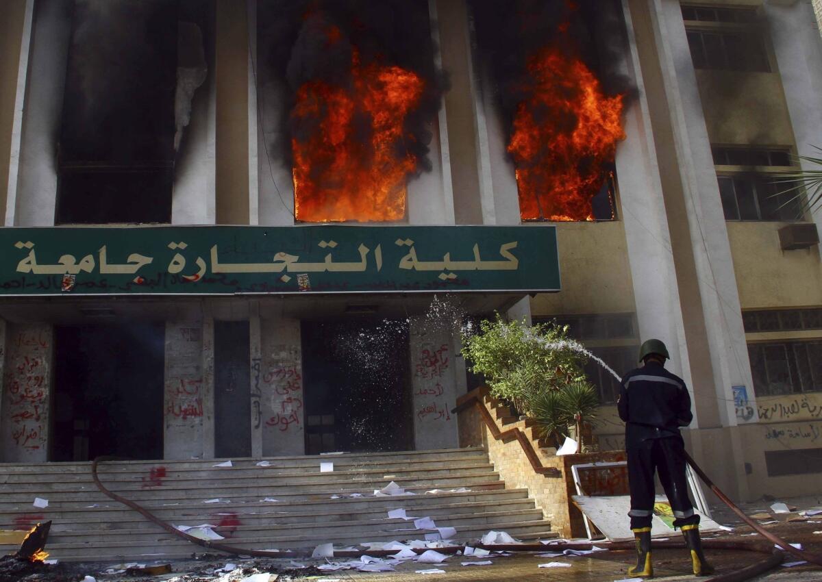 A firefighter sprays water on the Faculty of Commerce building at al-Azhar University in the Nasr City suburb of Cairo, set ablaze after a student was killed during clashes with security forces.