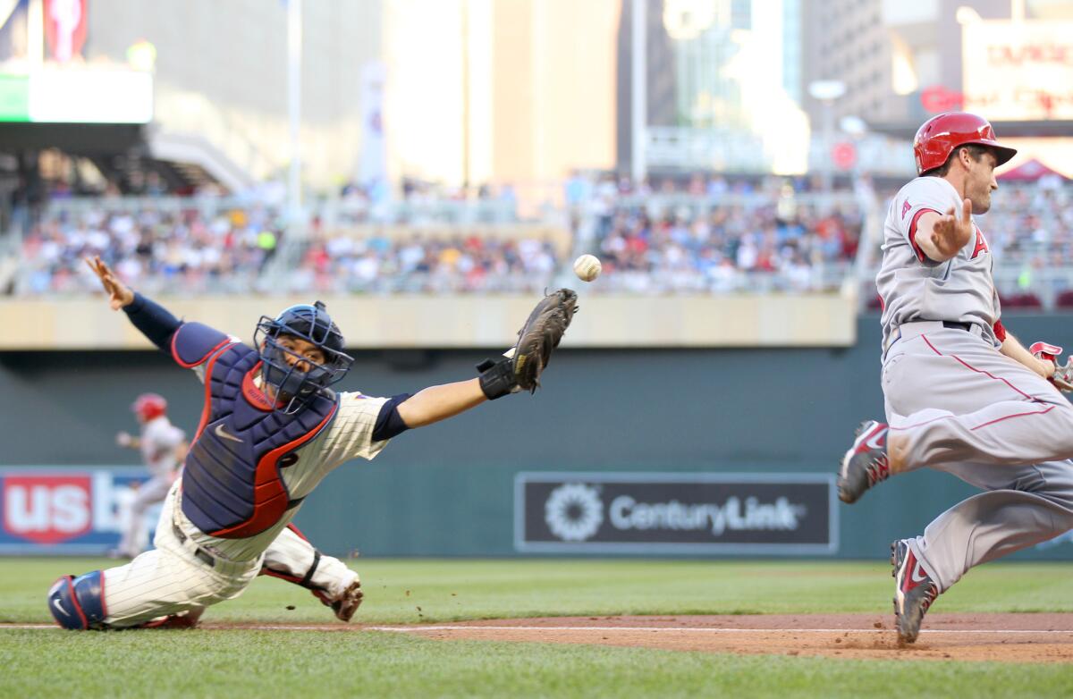 Minnesota catcher Kurt Suzuki doesn't get the tag on David Freese, who scores for the Angels in the second inning on Saturday.