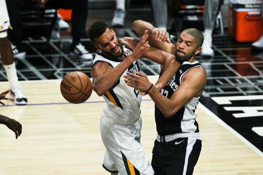 Clippers forward Nicolas Batum battles for a rebound against Jazz center Rudy Gobert.