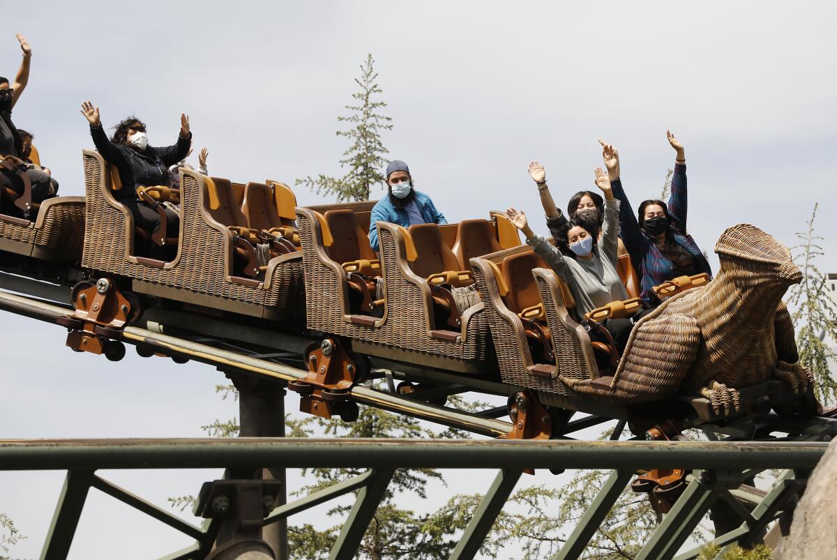 Masked and socially distant people on a roller coaster.