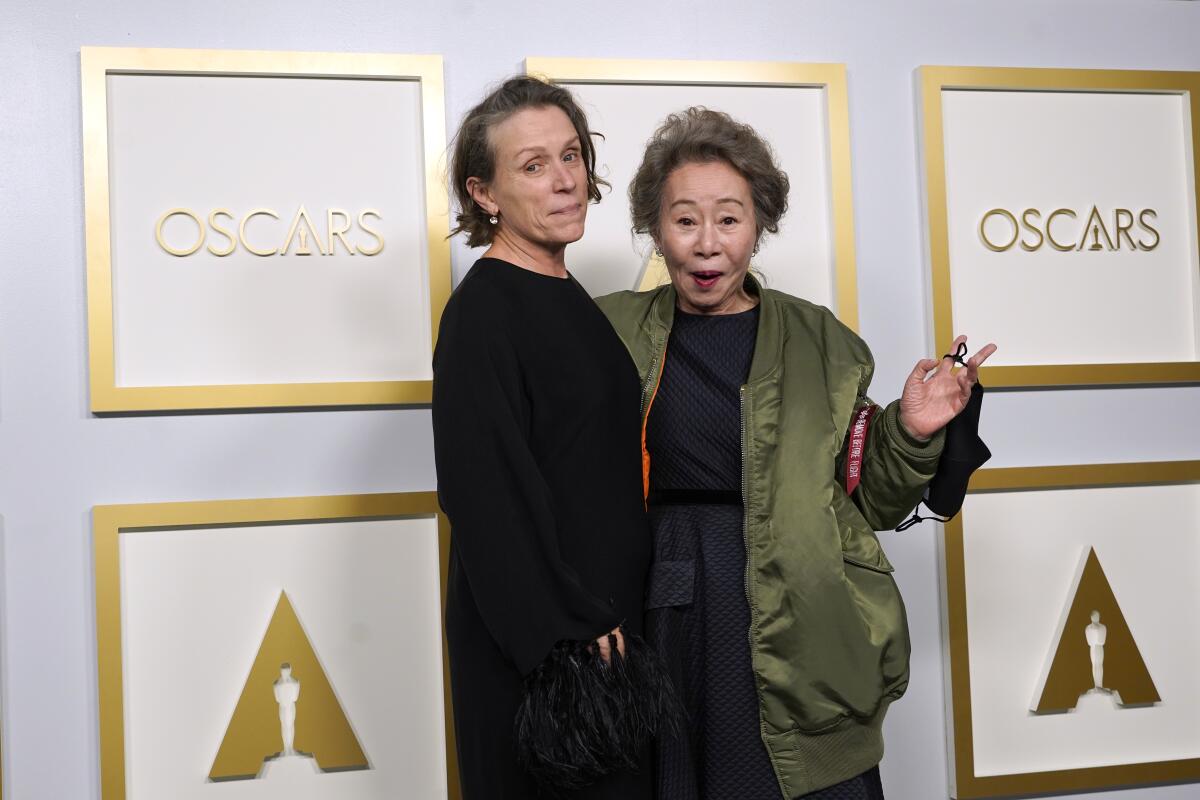 Frances McDormand and Yuh-Jung Youn stand together off stage after receiving their Oscars