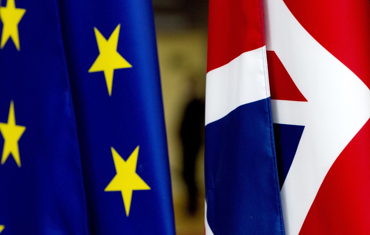 F|ILE - In this file photo dated Tuesday, Jan. 28, 2020, the British Union flag, right, and the EU flag, seen inside the atrium at the Europa building in Brussels. The number of Britons moving to live in European Union countries has soared since the Brexit vote in 2016, a U.K.-German study has revealed Tuesday Aug. 4, 2020.(AP Photo/Virginia Mayo, FILE)