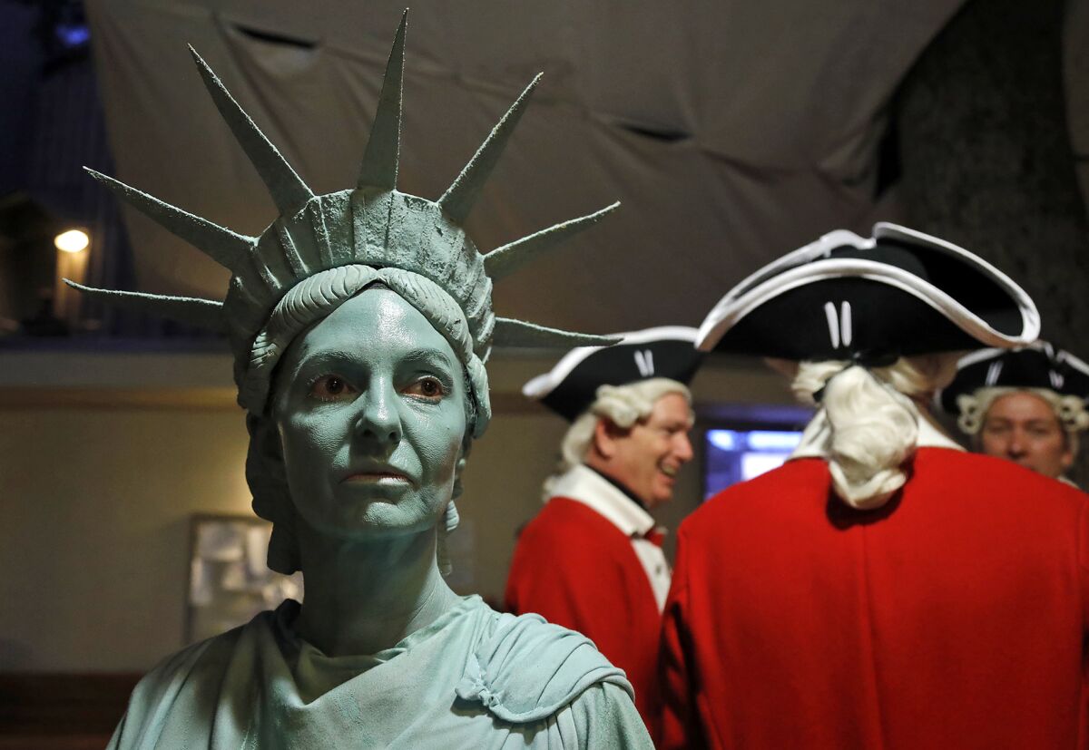 Michelle Liggatt, as the Statue of Liberty, with red coats at the 2021 Pageant of the Masters "Made in America" show.