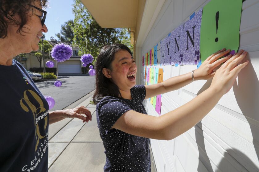 LAGUNA NIGUEL, CA -JULY11: Rachel Heuser, left, a retired teacher of the visually blind, gives a festive welcome to Lynn Wu when she arrives at her home to give Braille Challenge Finals test. Residence on Saturday, July 11, 2020 in Laguna Niguel, CA. (Irfan Khan/Los Angeles Times)