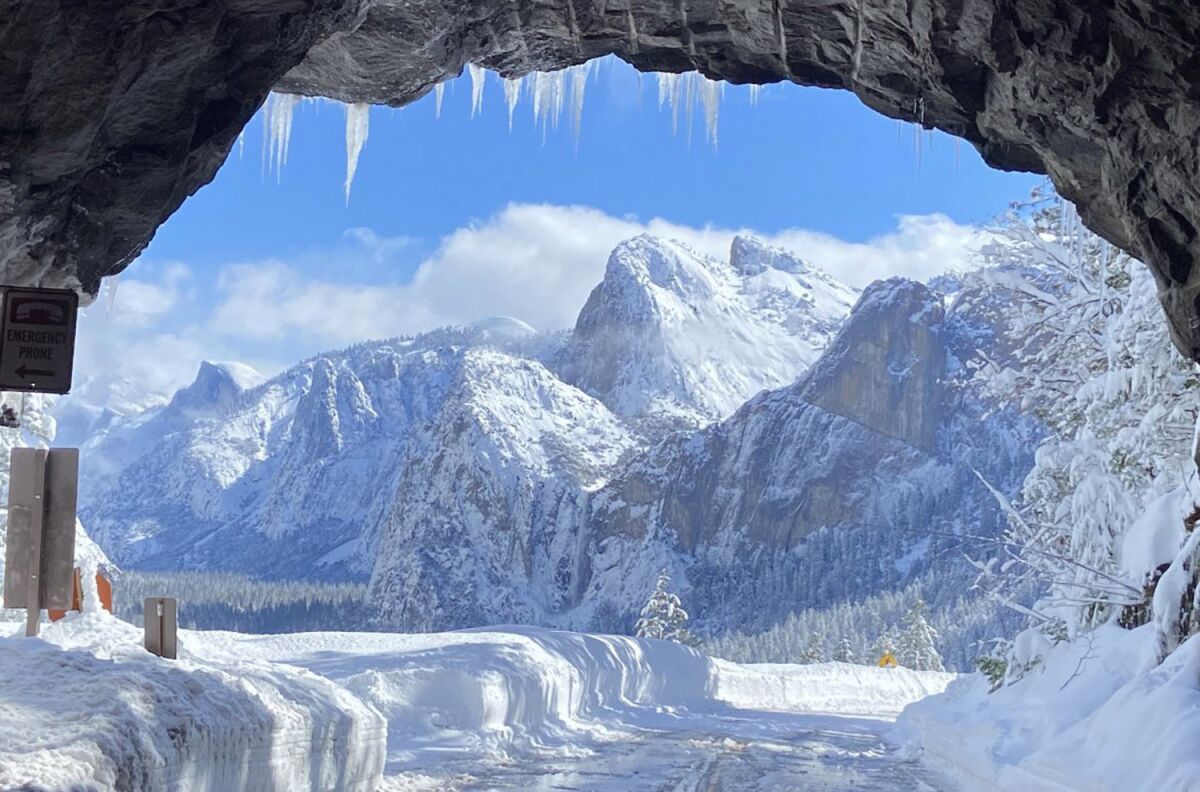 A photo taken from a tunnel shows snow-capped mountains in the distance.