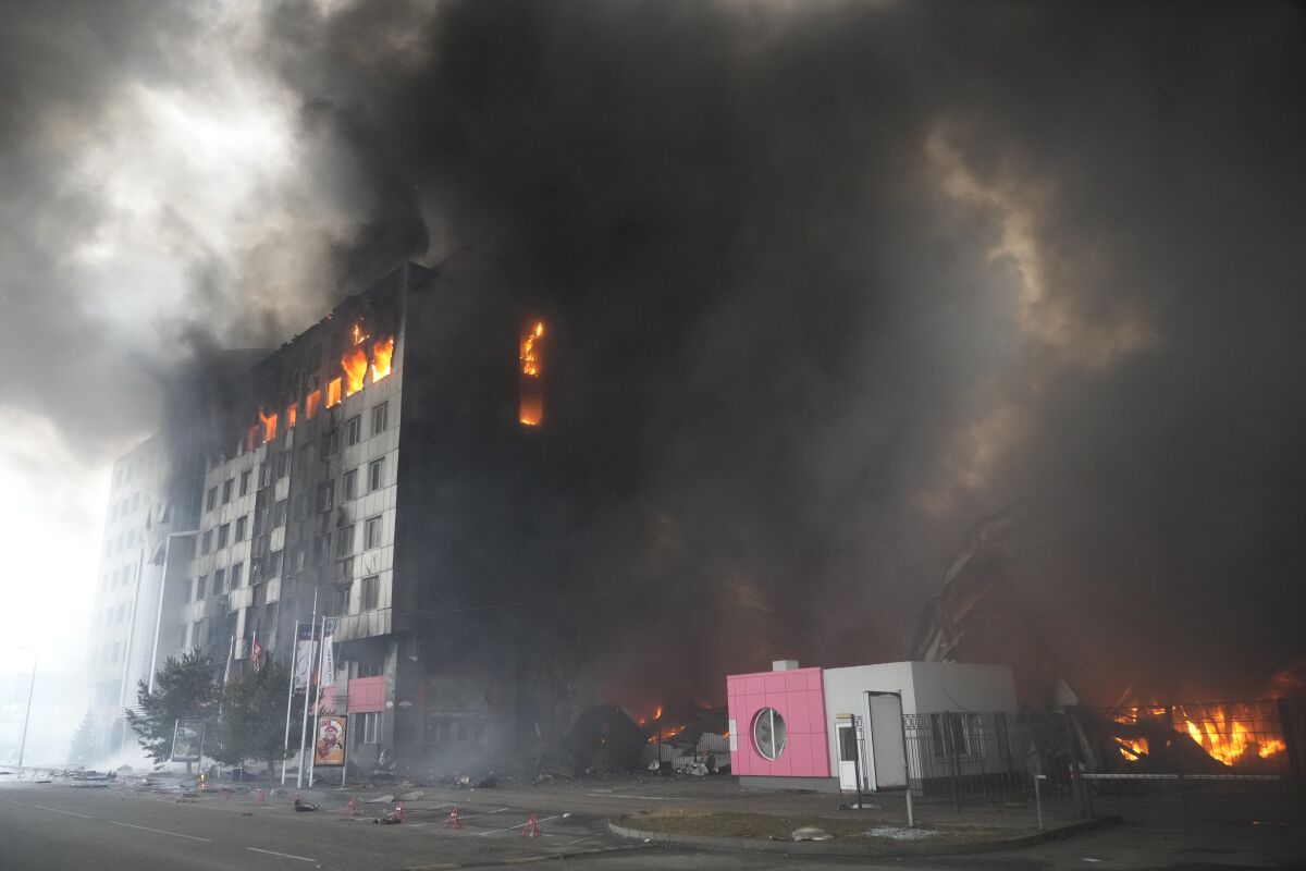 Black smoke pours from a building engulfed in fire