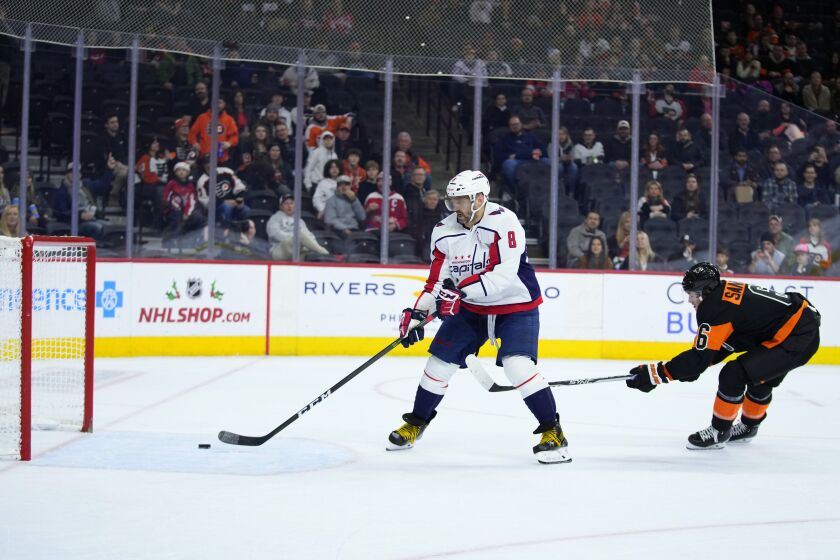 Washington Capitals' Alex Ovechkin scores a goal as Philadelphia Flyers' Travis Sanheim defends during the third period of an NHL hockey game, Wednesday, Dec. 7, 2022, in Philadelphia. (AP Photo/Matt Slocum)