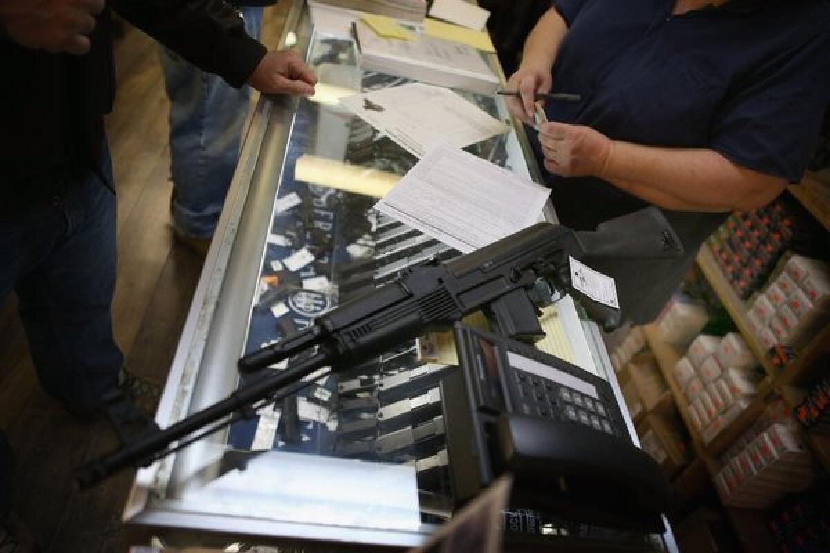 A customer purchases an AK-47 style rifle in Tinley Park, Ill. Gun sales have surged recently following the mass shooting in Connecticut.