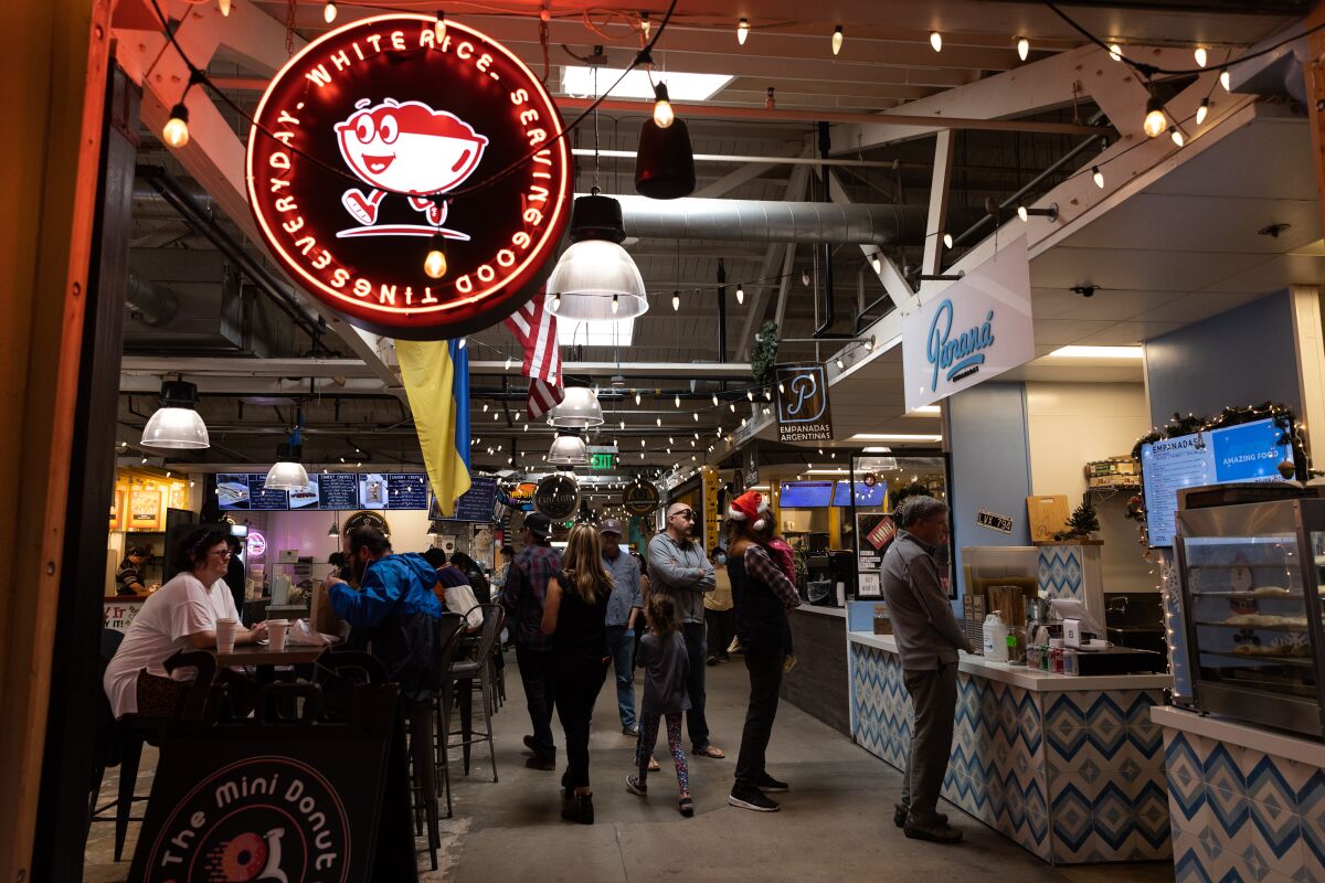 Shoppers wait in line for food at the Liberty Public Market on Christmas Eve Saturday, December 24, 2022.
