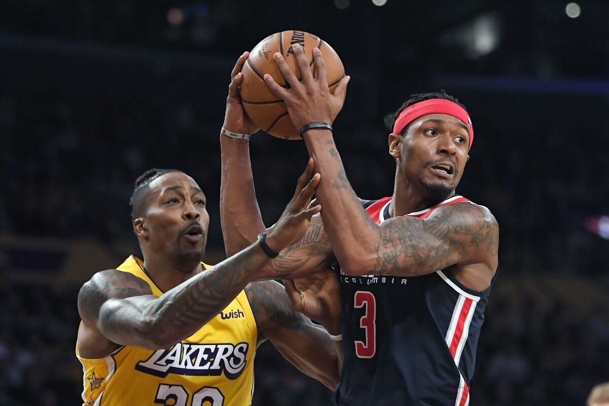 Wizards guard Bradley Beal tries to pass the ball while being defended by Lakers center Dwight Howard during a game Nov. 29.