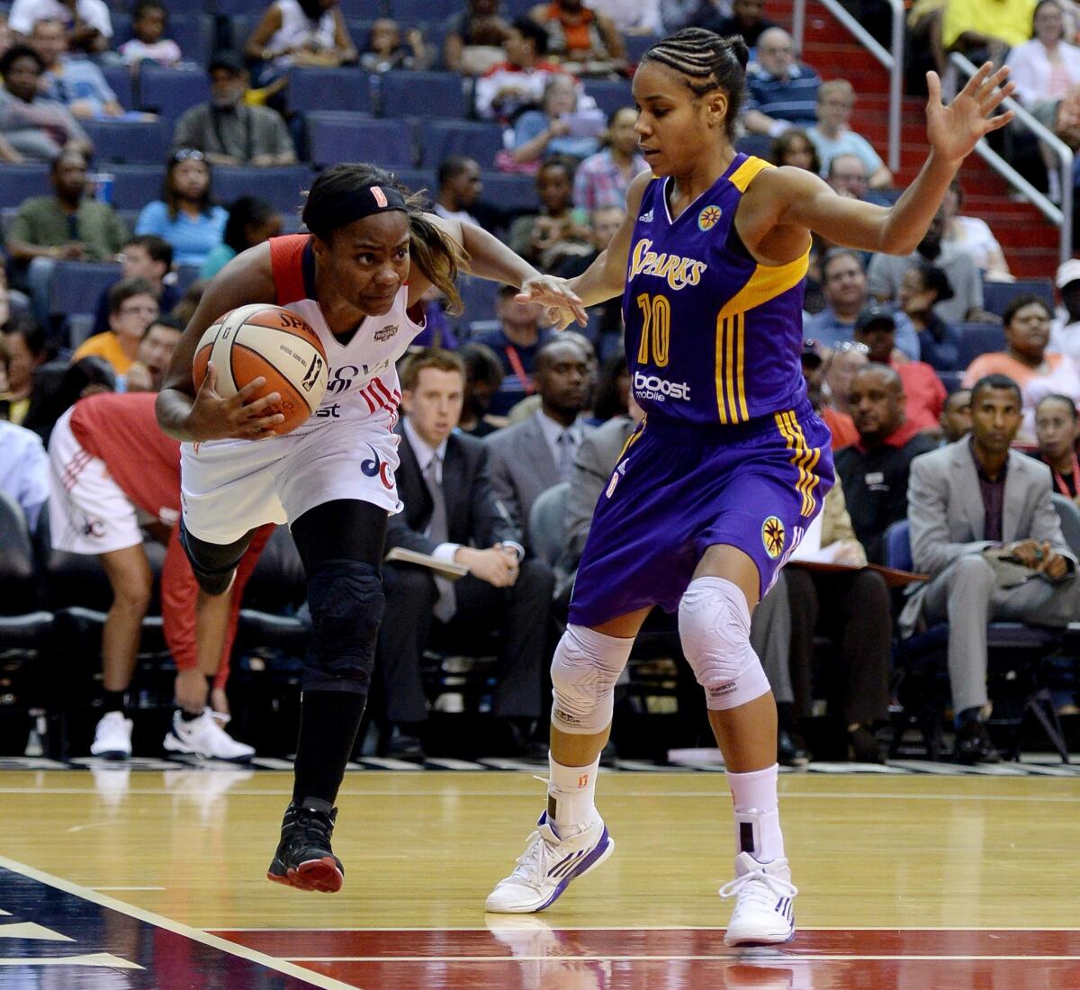 Washington's Ivory Latta, left, drives past the Sparks' Lindsey Harding, right, during a game June 1.