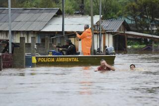 Agentes de policía revisan una casa mientras habitantes vadean una calle inundada por tormentas derivadas de un ciclón en Passo Fundo, en el estado de Rio Grande do Sul, Brasil, el lunes 4 de septiembre de 2023. (AP Foto/Diogo Zanatta-Futura Press)