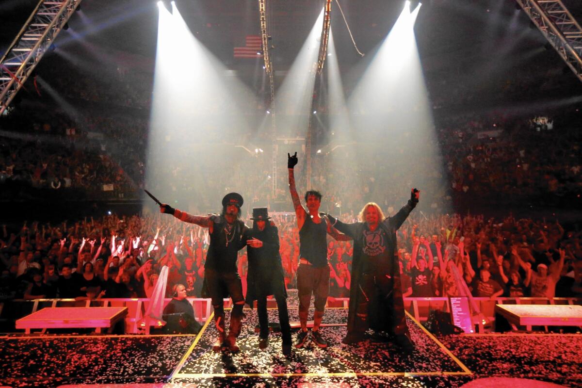 Motley Crue's Nikki Sixx, left, Mick Mars, Tommy Lee and Vince Neil celebrate the ending of another concert as the audience cheers at the Matthew Knight Arena in Eugene, Ore., on July 22, 2015.