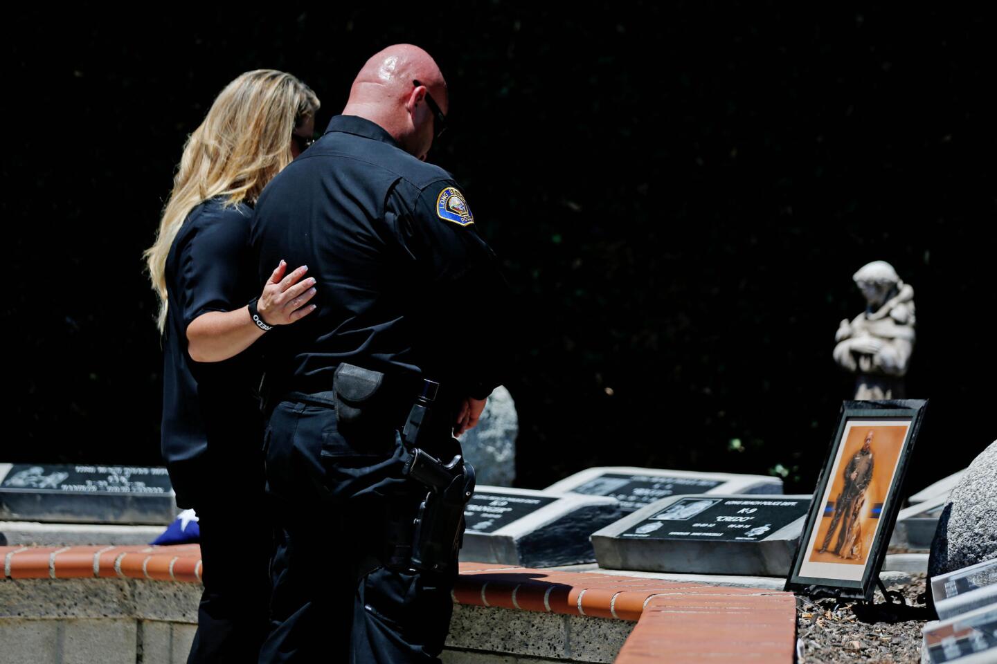 Long Beach Police Officer Mike Parcells, with his wife, Lisa Parcels, pays his last respects to his partner, service dog Credo, during a memorial service at the Long Beach Police Officers Park.