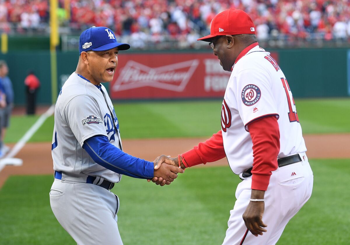 Dodgers Manager Dave Roberts and Nationals Manager Dusty Baker shake hands before Game 1 of the NLDS.