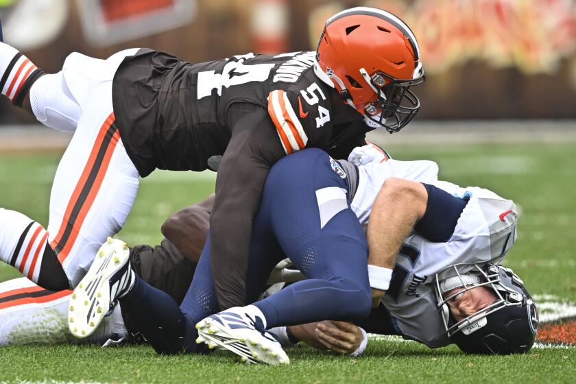 Tennessee Titans quarterback Ryan Tannehill, right, is sacked by Cleveland Browns defensive end Ogbo Okoronkwo (54) and defensive end Myles Garrett, behind, during the first half of an NFL football game Sunday, Sept. 24, 2023, in Cleveland. (AP Photo/David Richard)