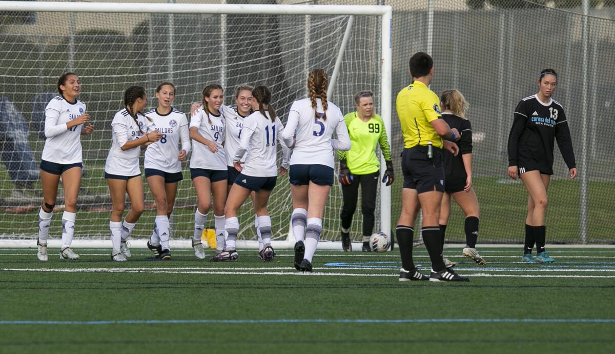 Newport Harbor's Sadie Hoch is mobbed by her teammates after scoring a goal in Thursday's match.