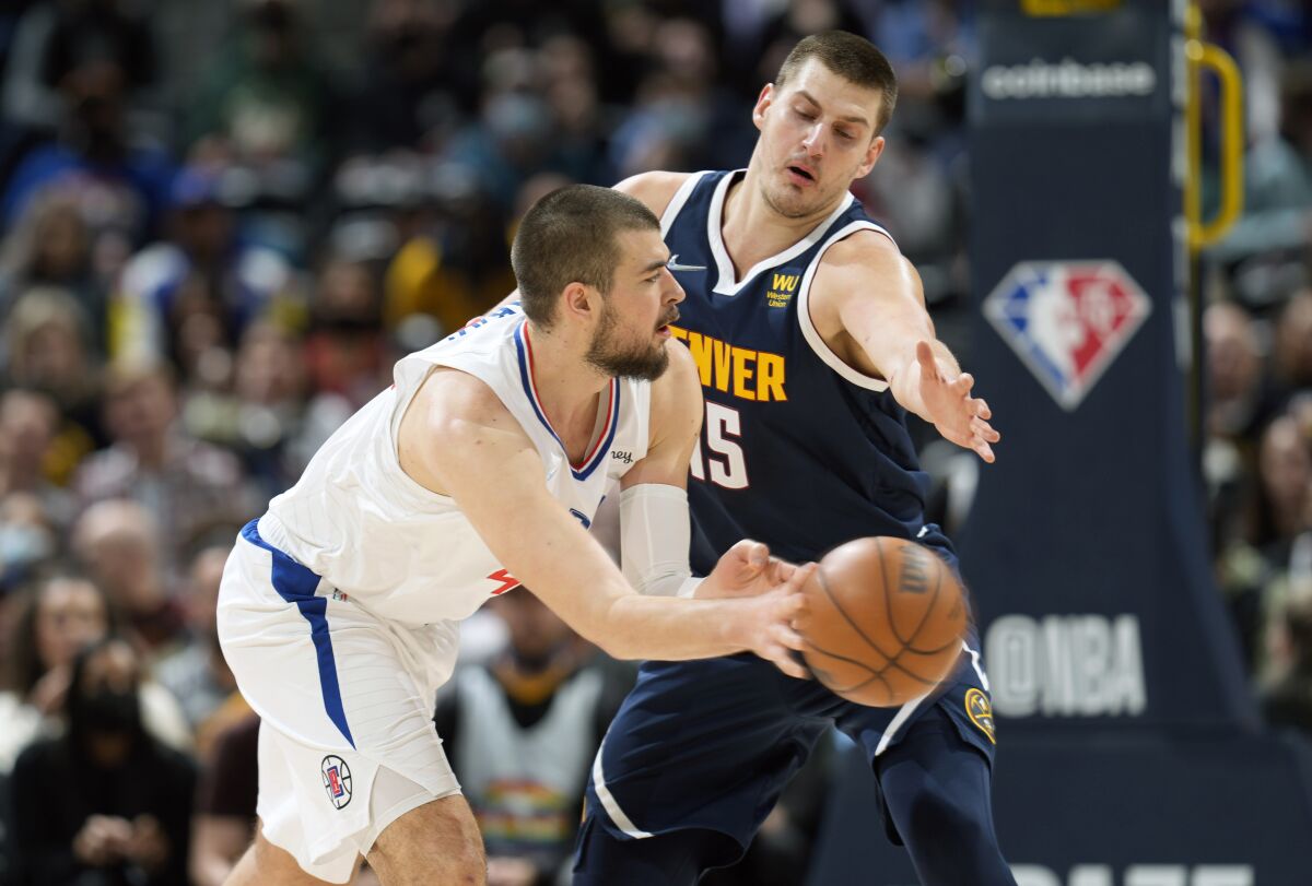 Clippers center Ivica Zubac passes the ball as Denver Nuggets center Nikola Jokic defends.