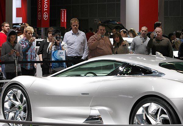 Auto fans gather to view and photograph the Jaguar C-X75 during the first day of the 2010 Los Angeles Auto Show at the Los Angeles Convention Center.
