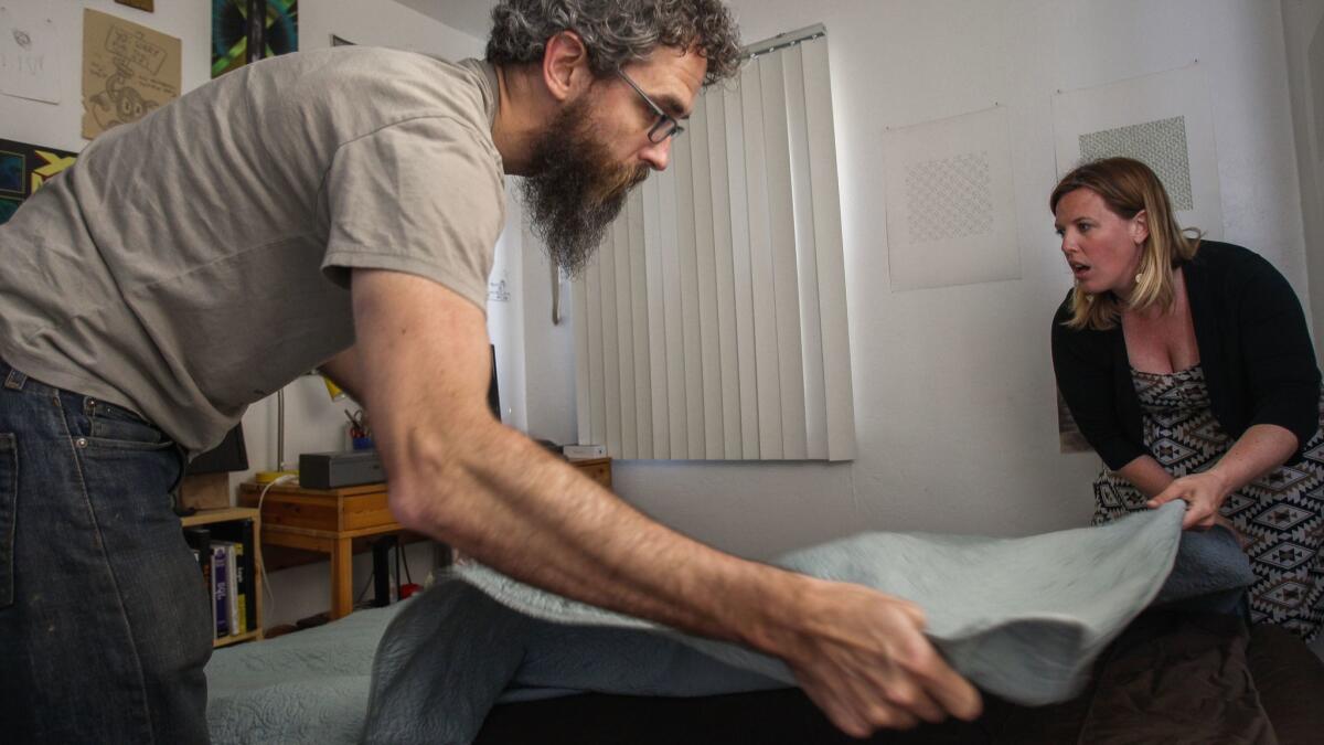 Blair Overstreet and her husband Matt Dunn spreads a blanket over an inflated mattress in their spare bedroom in hopes of being able to offer the room to a family that is part of the Central American caravan seeking asylum in the U.S.